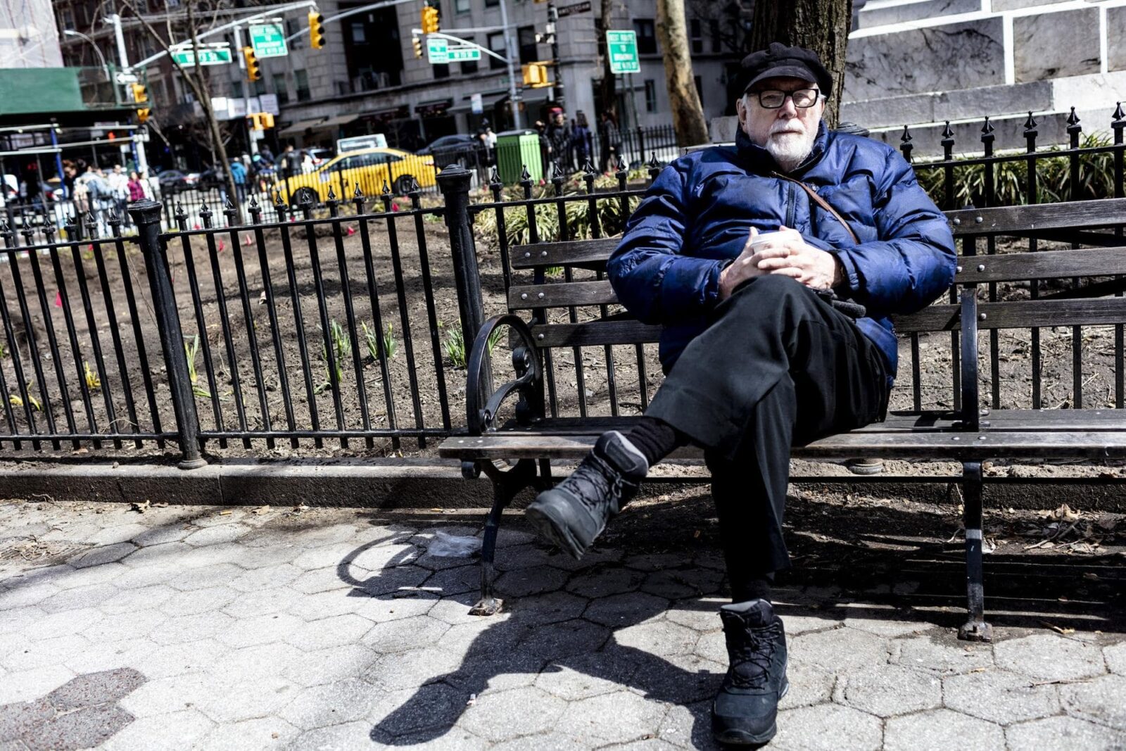 Man Sitting on Park Bench in City