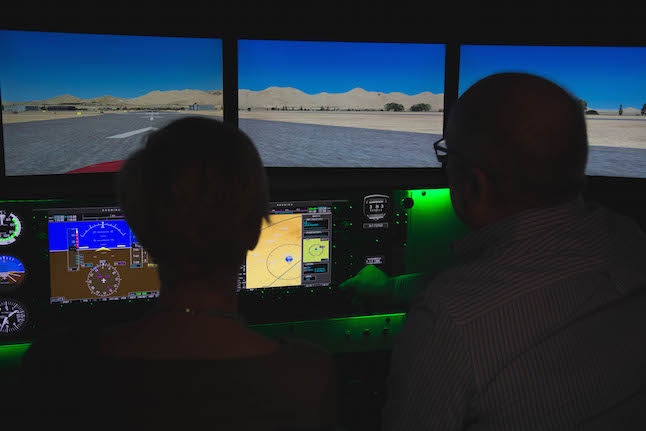 Aerodyne Flight Center co-founder Doug Cox, right, teaches the author some aviation basics in the Redbird Flight Simulator.