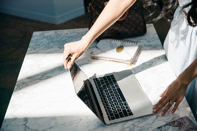 Woman Viewing Laptop On Marble Table