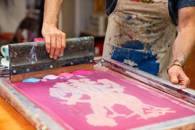 Person Screenprinting A Design With Multiple Paint Colors