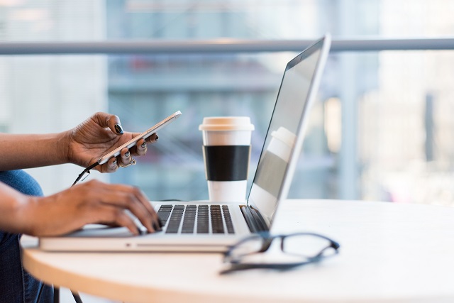 Woman Using A Laptop And Mobile Phone