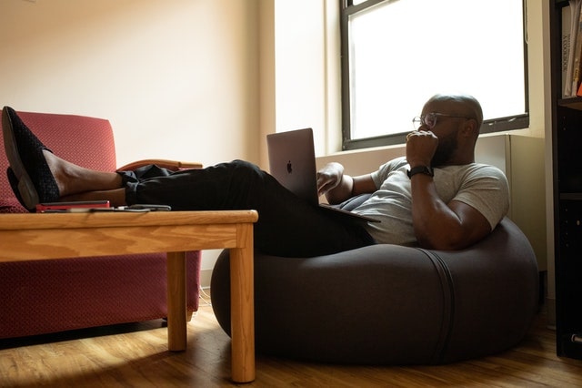 Man working from home on bean bag chair