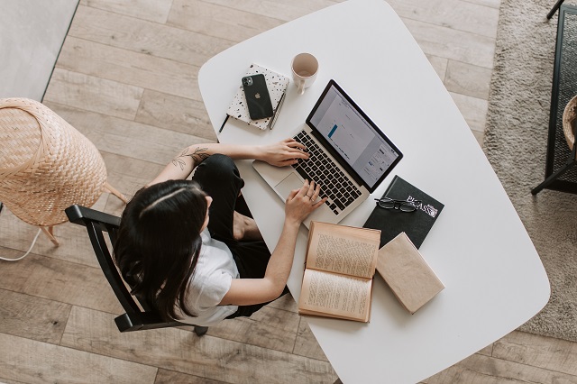 Woman working at a desk to illustrate webinar sales funnel