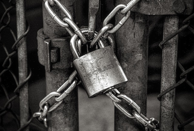 black and white lock on chainlink fence