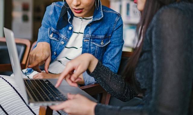 Women in business meeting holding laptop