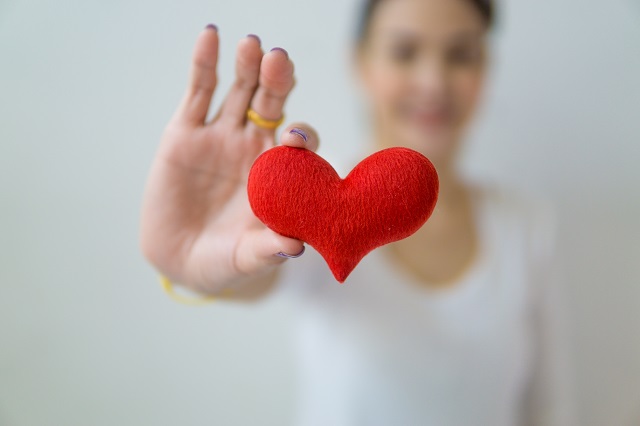 Woman holding red felt heart