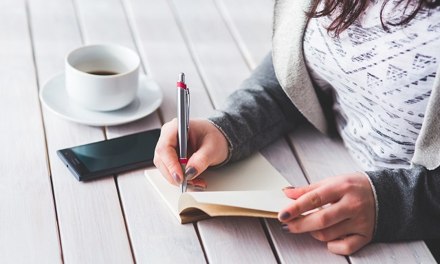 Woman taking notes on a wooden table