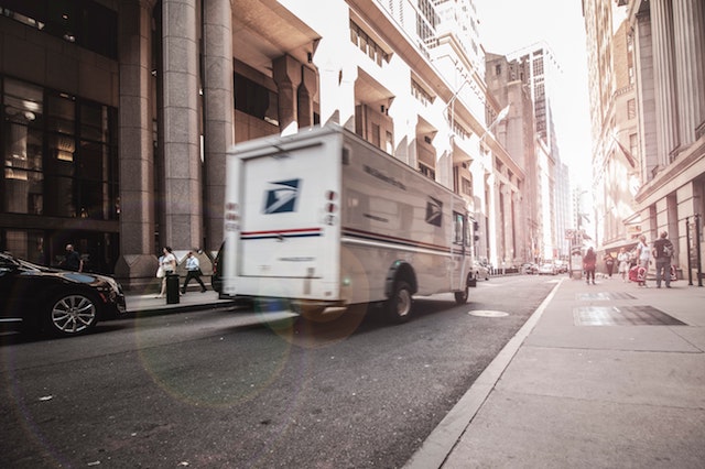 USPS truck driving through city