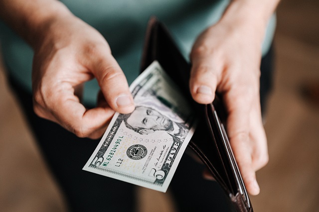 Person opening wallet to pay with cash