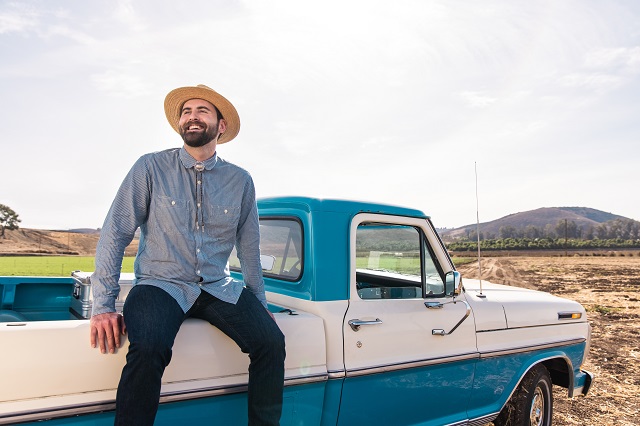 Evan Rochefort of NutraMaize sitting on blue truck bed