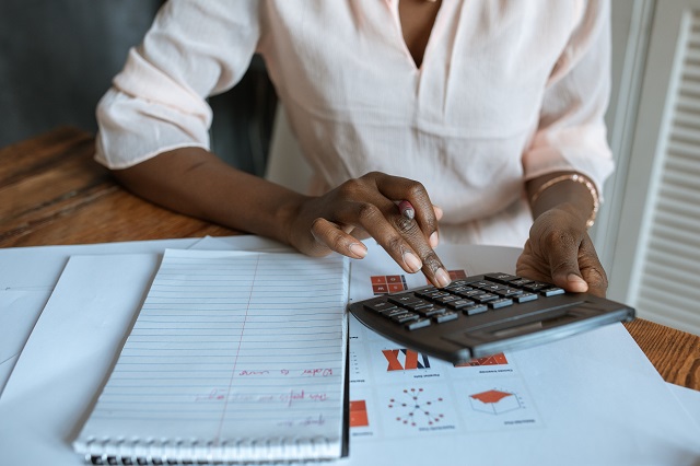 Woman using calculator at desk