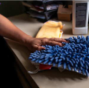 Person cleaning with a dust rag