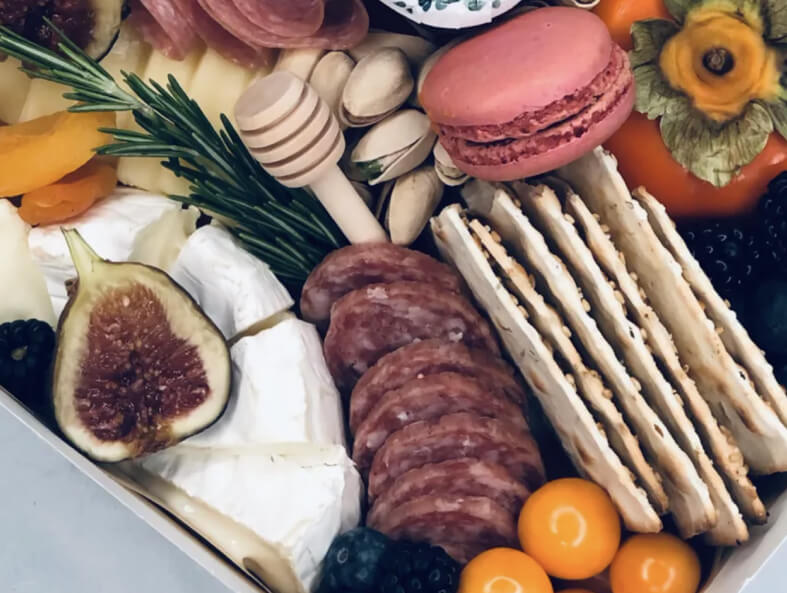To-go boxes from Fig & Brie with cheese, meat, and fruit