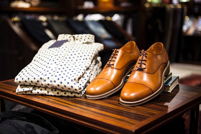 Leather dress shoes and button up shirt on a shelf