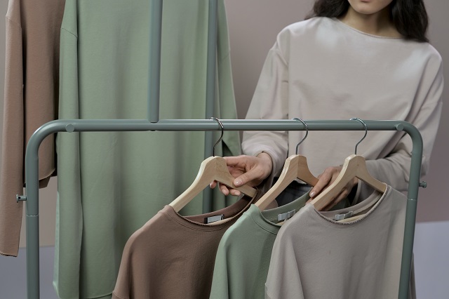 Woman sorting through rack of clothing