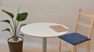 Laptop on table with chair and plant