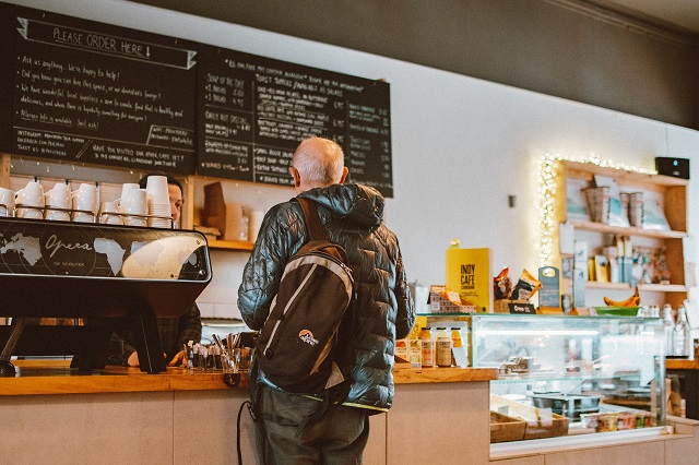 Customer standing at coffee shop counter