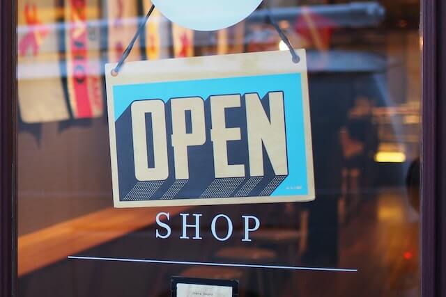 Open sign hanging on store front window