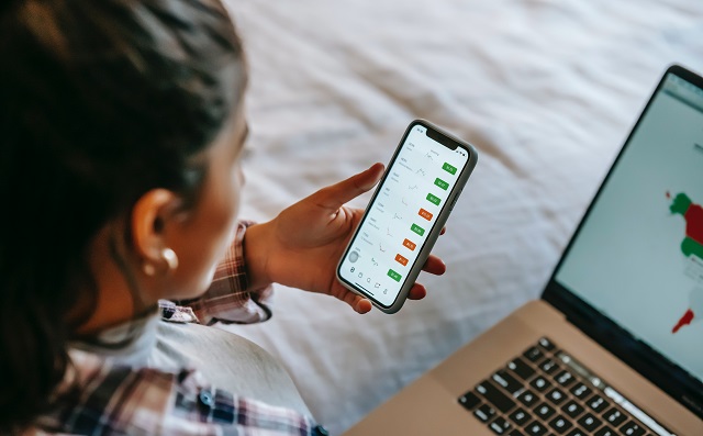 Woman checking prices on laptop and smart phone