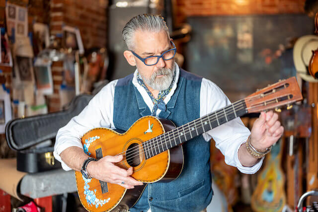 James A. Willis tuning a guitar