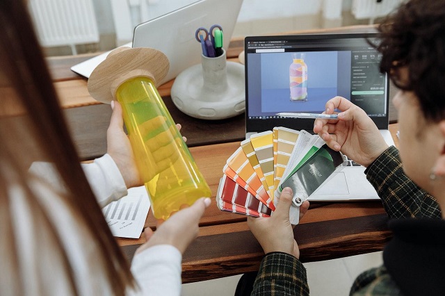 Two people sitting at a computer desk viewing color swatches