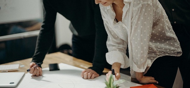 Two people standing at a drafting table