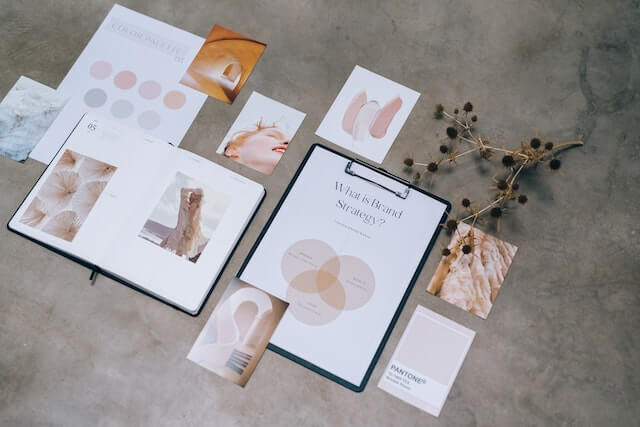 Color pallette and images spread on a table next to clipboard with paper that reads What is brand strategy?