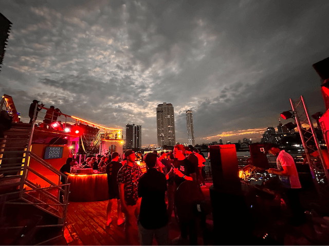 People chatting at the DJ at a GoDaddy boat party