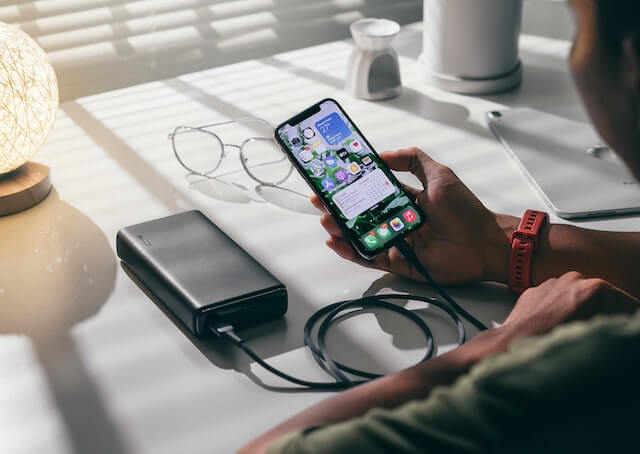 Close-up of man looking at mobile phone with an attached power bank