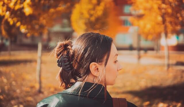 Side profile of brunette woman modeling a black hair clip