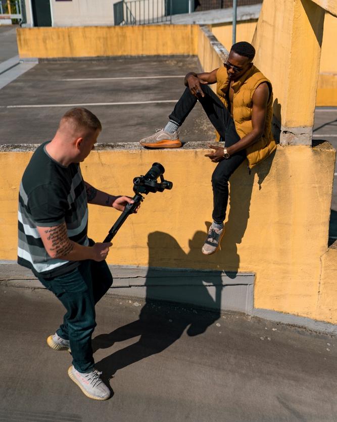 Two male content creators filming in a parking lot