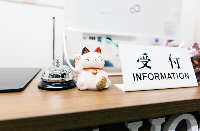 Lucky Cat And Japanese Information Sign On A Computer Desk