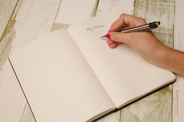 Woman Writing Outline In Journal