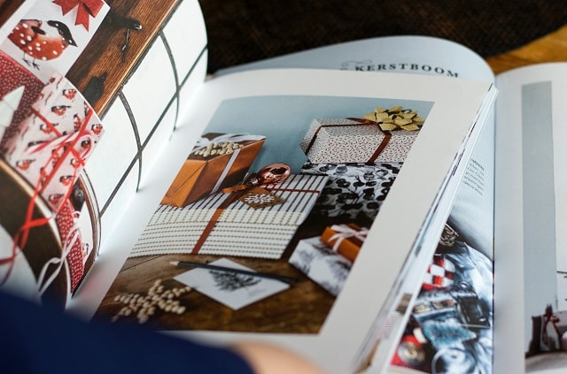 Customer Browsing Magazine For Holiday Gifts