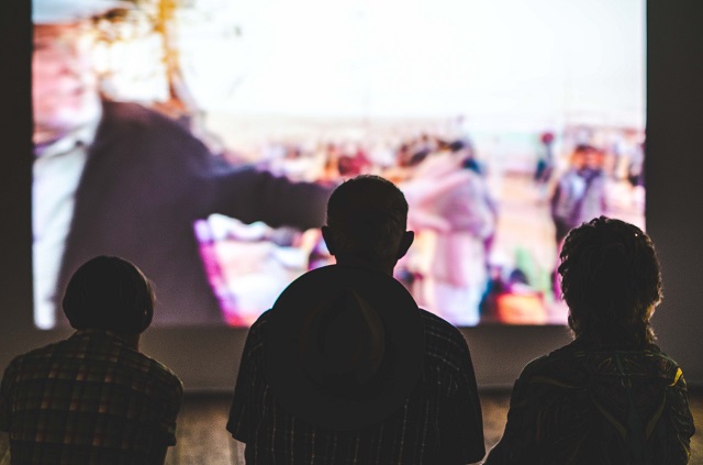 Three Men Watching Projected Video