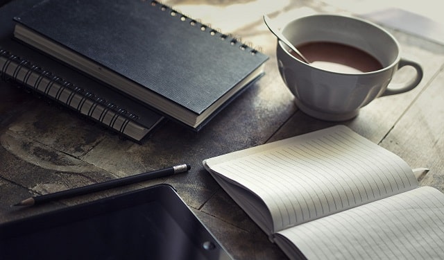 Open Notebook With Tablet and Coffee Nearby