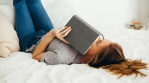 How to Write Product Descriptions Woman Reading Book In Bed