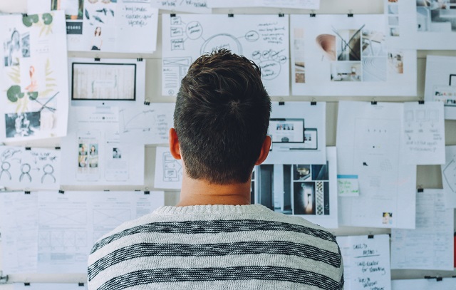 Man Looking At Bulletin Board For Inspiration