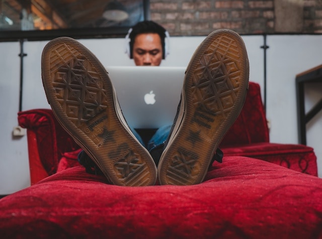 Man Working on Laptop on Sofa Illustrates Freelance Considerations