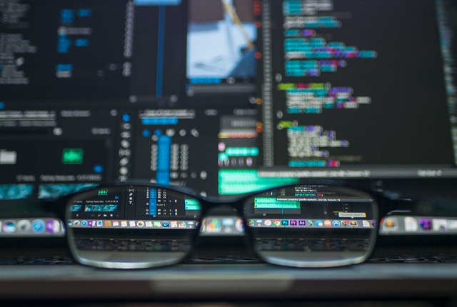 Glasses Resting In Front Of Computer Screen With Code