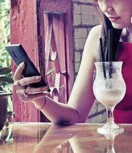 Woman on Smartphone with Cocktail