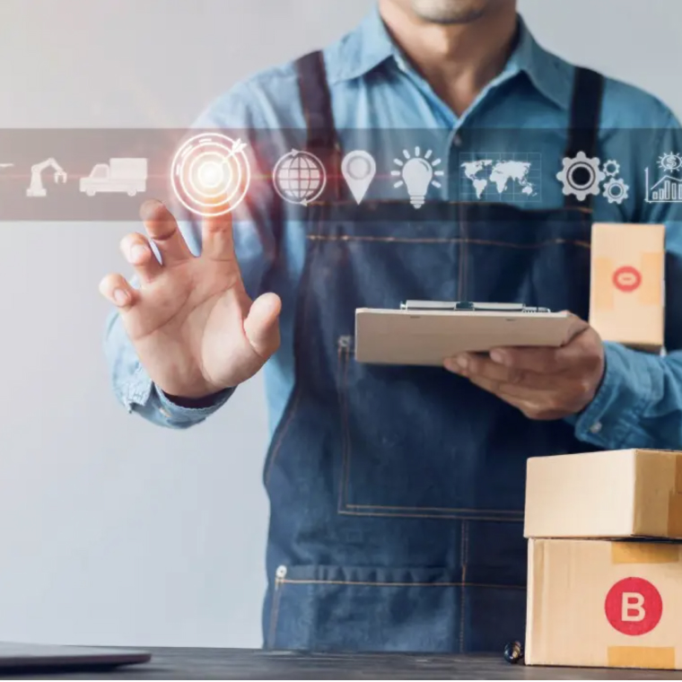 Worker in denim apron using digital logistics interface with packages