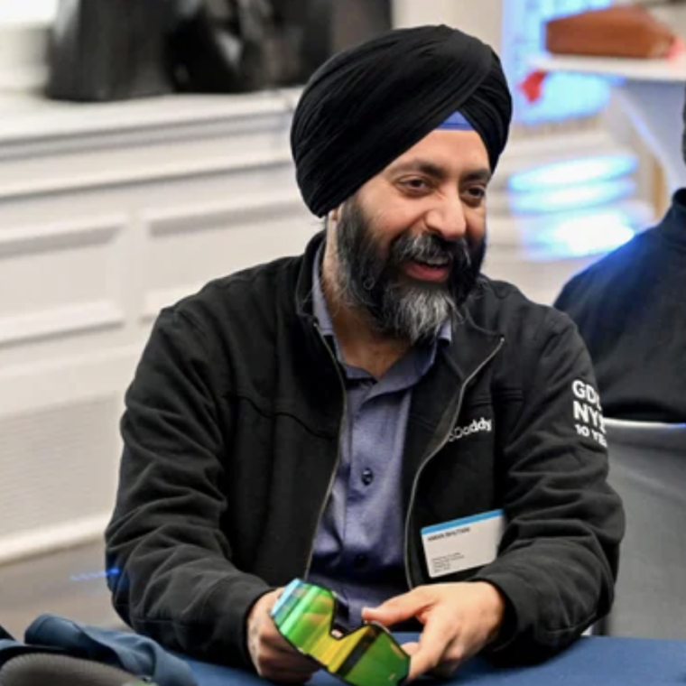 Man holding Goggins Goggles while seated at event table