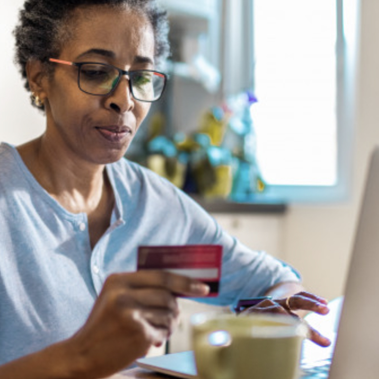 Woman using credit card for online payment on laptop