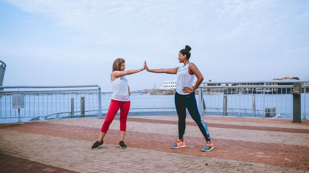 Two women high fiving on pier