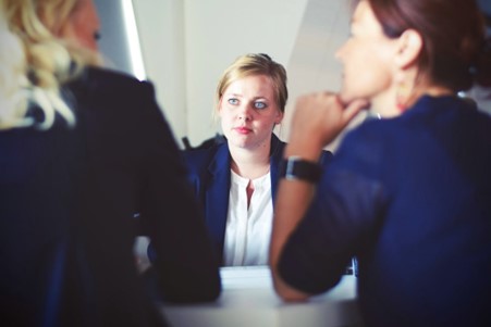 a lady getting interviewed by 2 other ladies during a recession