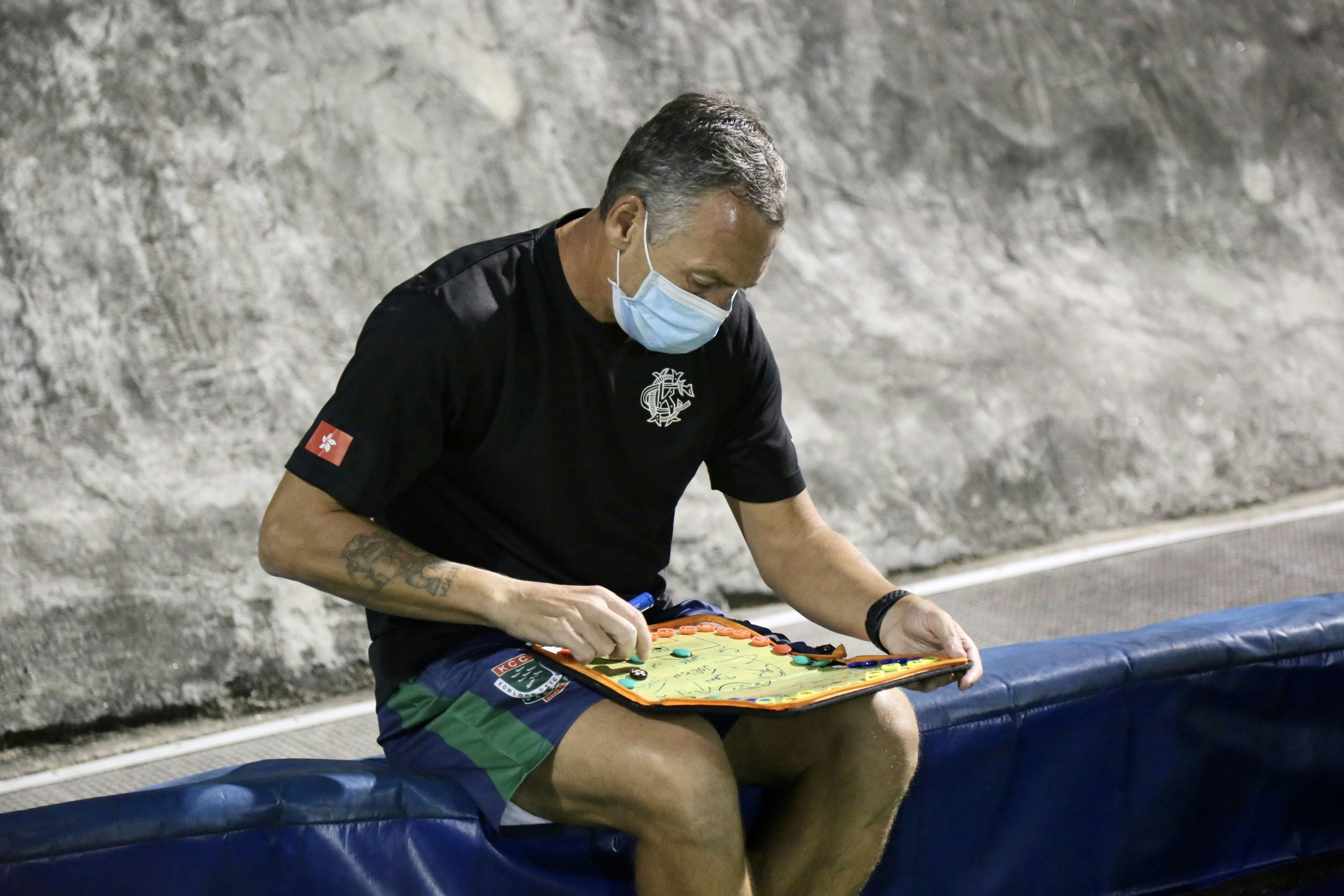a man preparing a tactical plan for a team photo taken by a sports writer