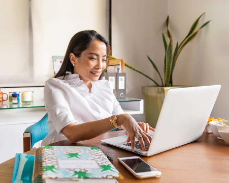 Woman With Laptop Using GoDaddy Email Marketing