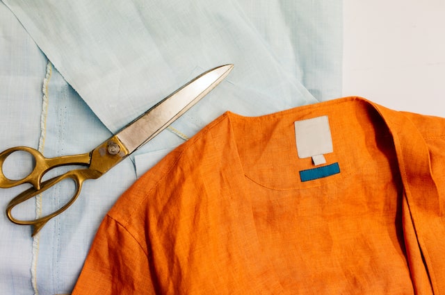 Orange shirt laying on cutting board with scissors