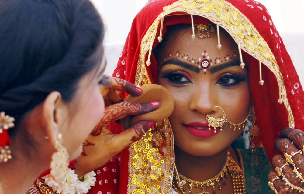 MAKEUP ARTIST TOUCHING UP THE MAKEUP OF A BRIDE IN KARACHI.
